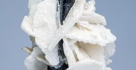 A cluster of white and black crystals on a table in color