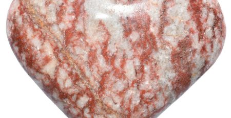 A red and white heart shaped stone on a white background.