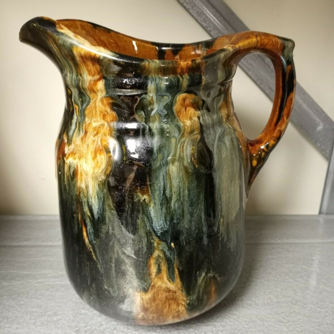 A black and brown jug sitting on a table.