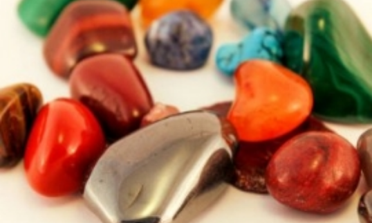 A group of colorful stones on a white surface in color