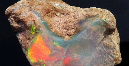 A rock with a piece of opal on it.