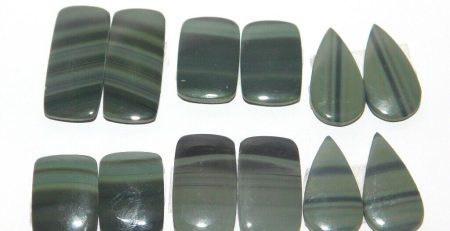 A group of green and black agate pieces on a white surface.