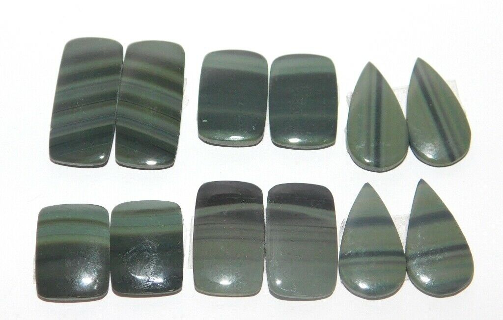 A group of green and black agate pieces on a white surface.