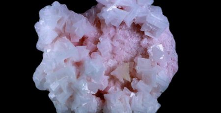 A cluster of pink crystals on a black background.