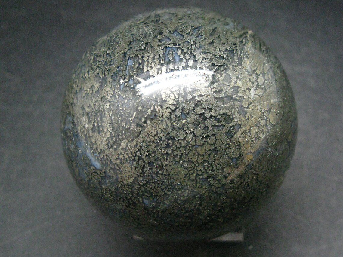 A stone ball with a black and grey pattern on it.