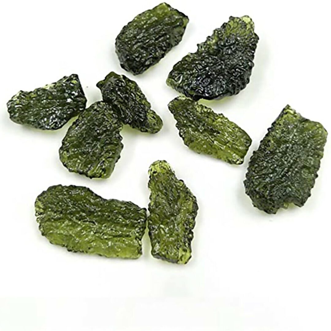 A group of green pieces of seaweed on a white surface.