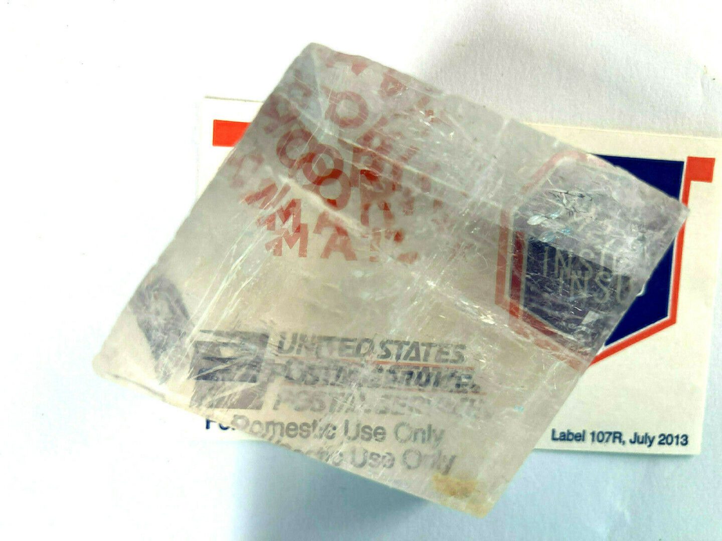 A piece of ice sitting on top of a piece of paper.