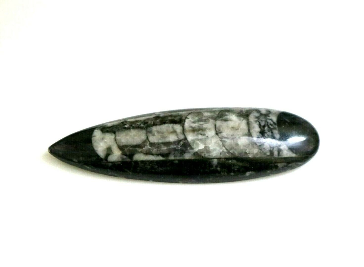 A black and white stone on a white surface.