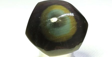 A black and green eye on a silver base.