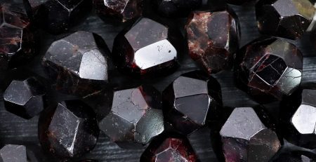 A bunch of black garnet stones on a table in color