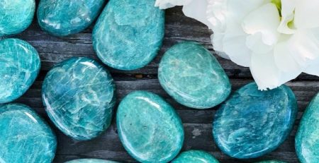 A group of turquoise stones with a white flower in turquoise