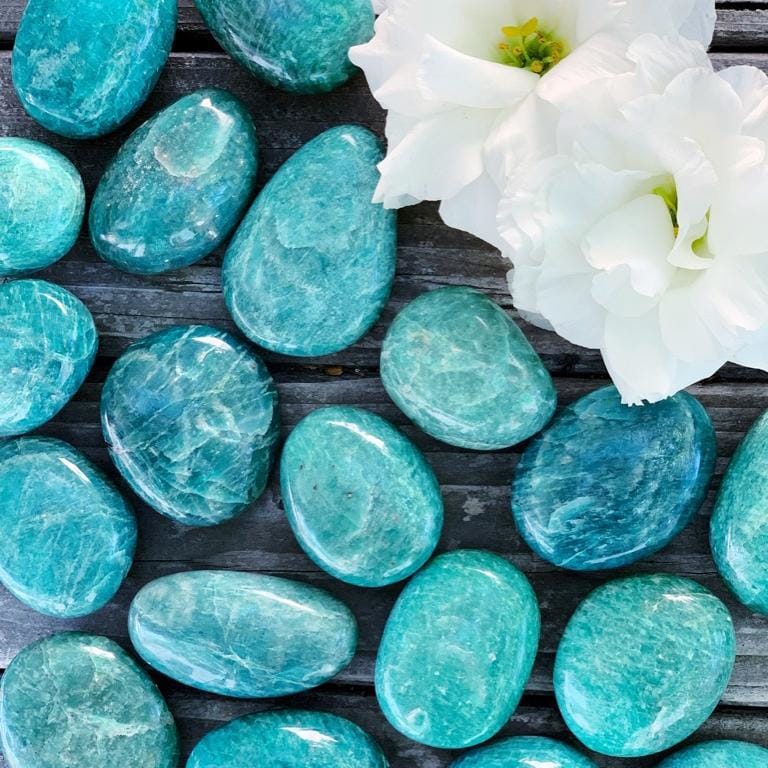 A group of turquoise stones with a white flower in turquoise