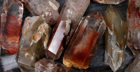 A bunch of quartz crystals on a table in brown color