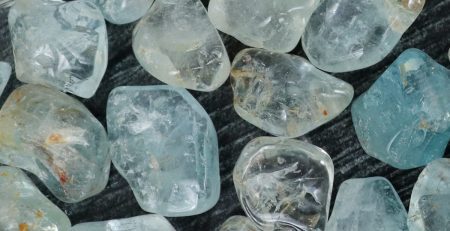 A bunch of aquamarine crystals on a table.