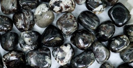 A bunch of black and white stones on a white surface.