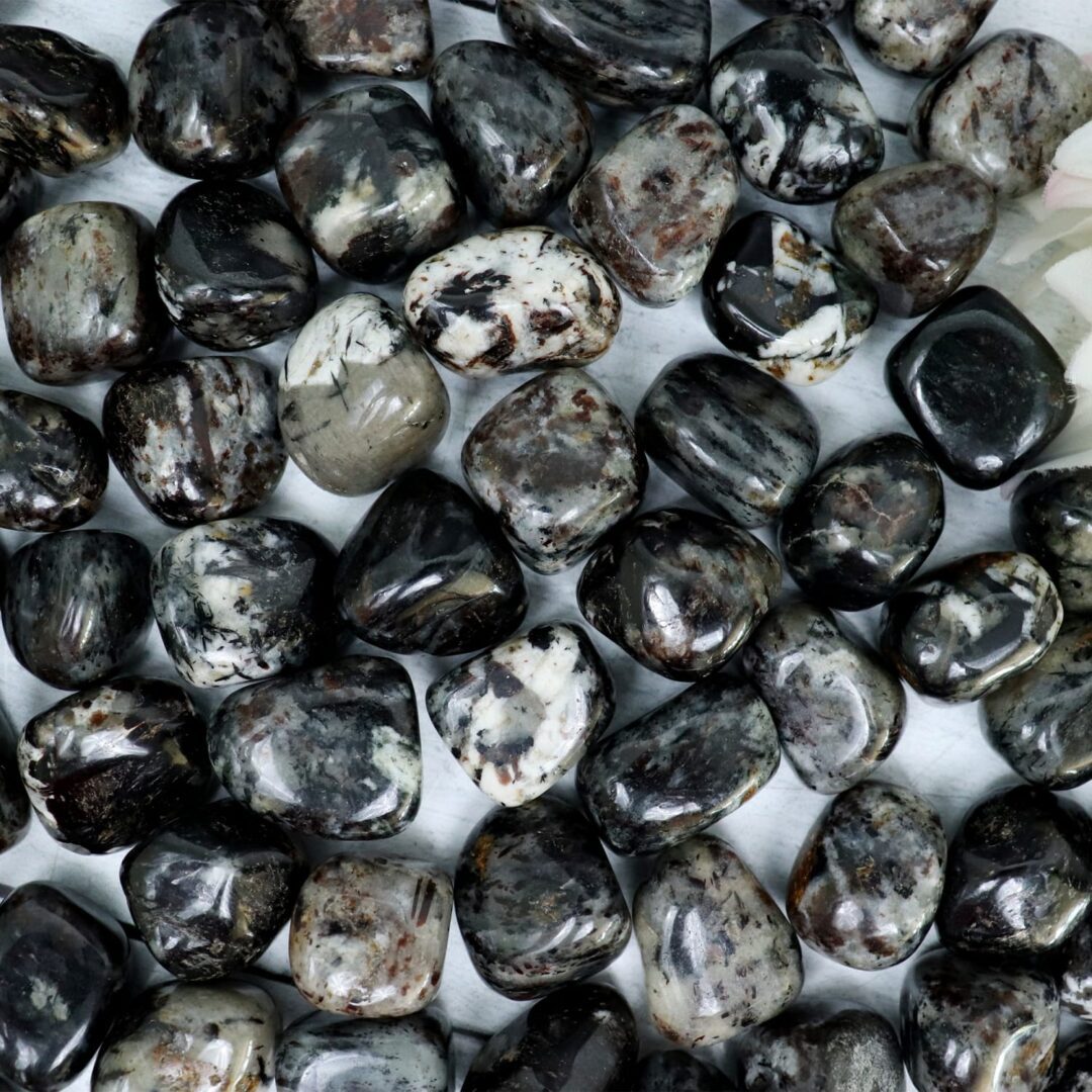 A bunch of black and white stones on a white surface.