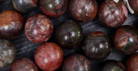 A bunch of red and brown marble beads on a table.