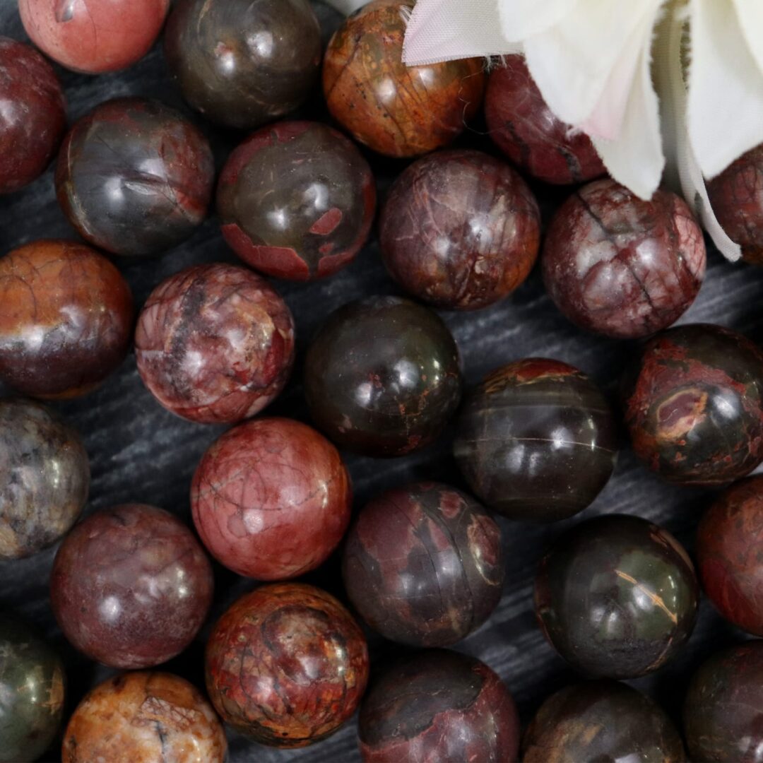 A bunch of red and brown marble beads on a table.