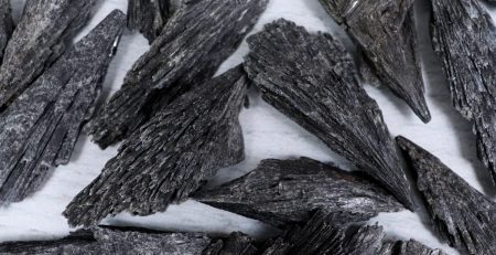 A pile of black rocks on a white surface.