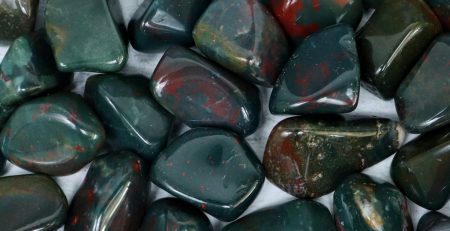 A pile of green and red stones on a white surface.