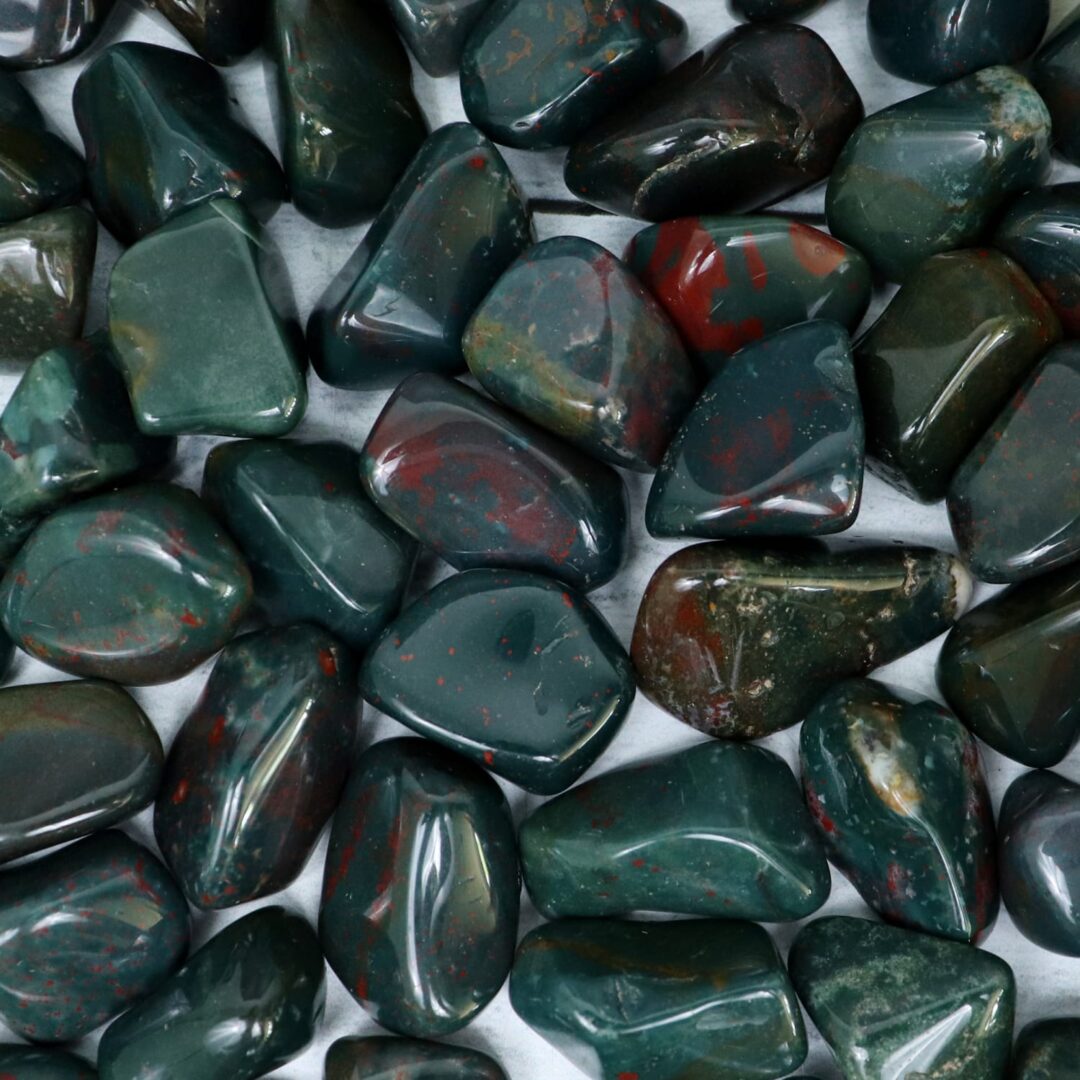 A pile of green and red stones on a white surface.