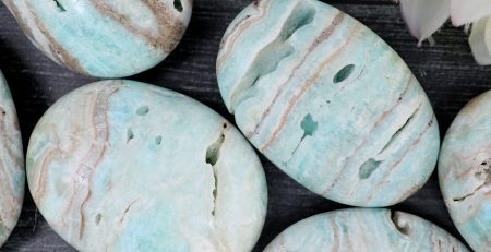 A bunch of green and blue marble stones on a table.