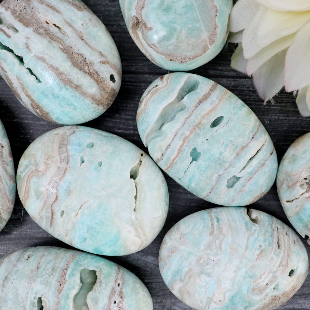 A bunch of green and blue marble stones on a table.