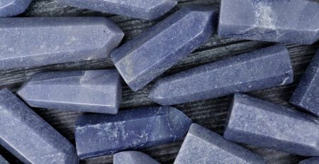 A bunch of blue quartz crystals on a wooden surface.