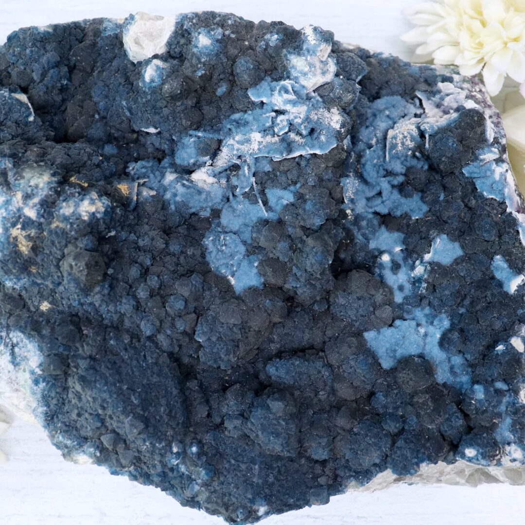 A rock with blue and white flowers on it.