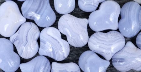 A bunch of blue heart shaped beads on a wooden table.