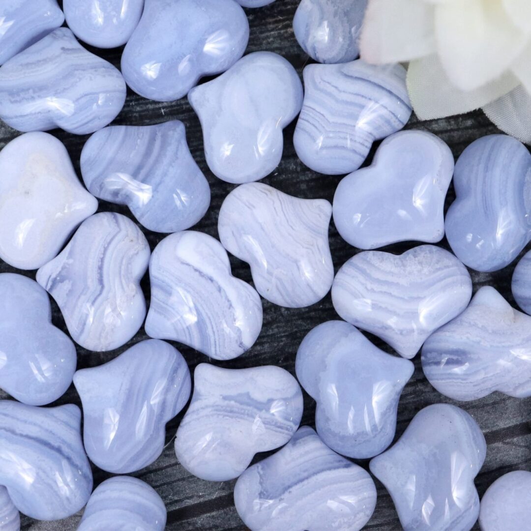 A bunch of blue heart shaped beads on a wooden table.