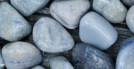 A pile of blue stones on a wooden surface.