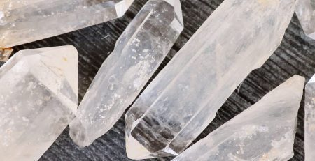 A group of crystal points on a wooden surface.