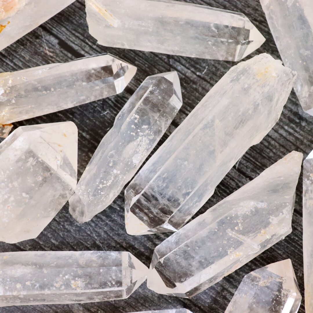 A group of crystal points on a wooden surface.