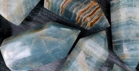 A group of blue apatite stones on a table.