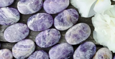 Purple amethyst gemstones on a wooden table.