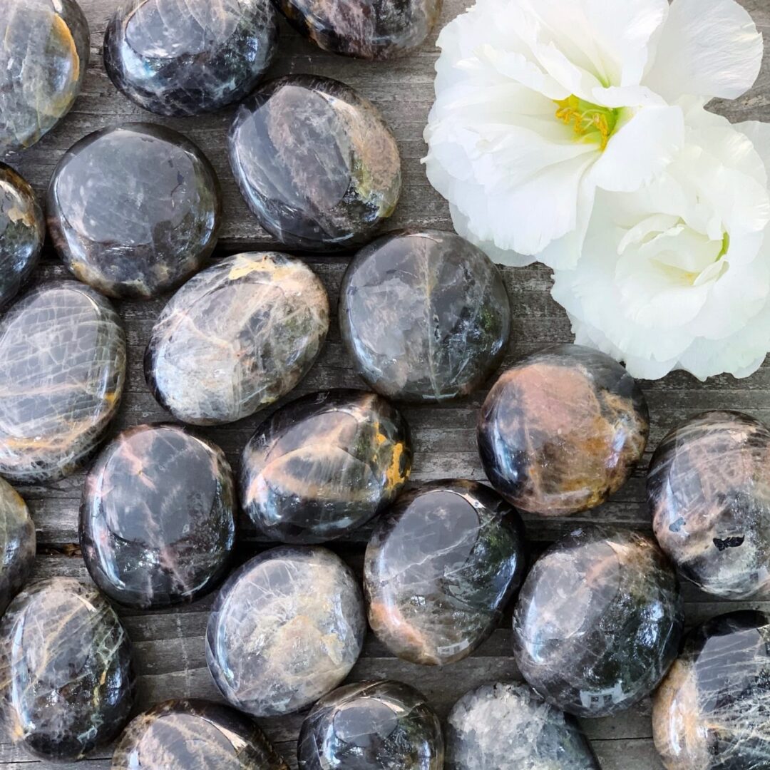 A bunch of black and white stones on a wooden table.