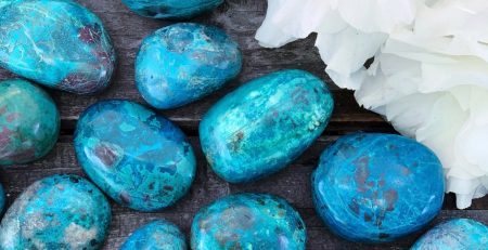 Turquoise stones and flowers on a wooden table.