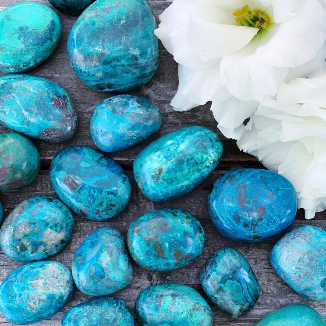 Turquoise stones and flowers on a wooden table.