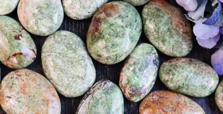 A bunch of green and brown stones on a table.