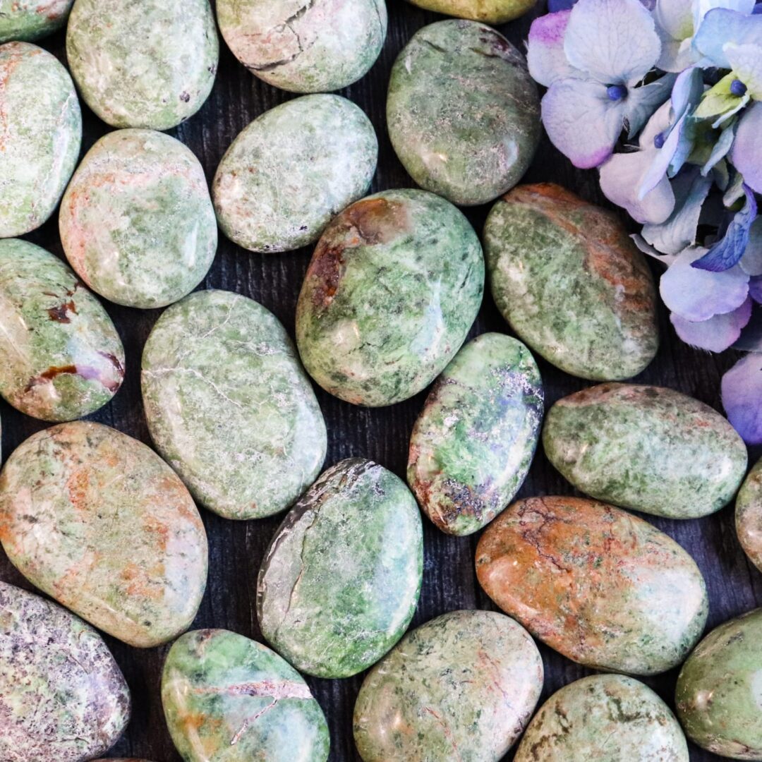 A bunch of green and brown stones on a table.