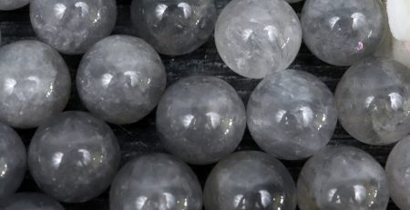 A bunch of grey quartz spheres on a table.