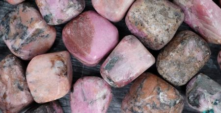 A pile of pink and gray stones on a wooden surface.