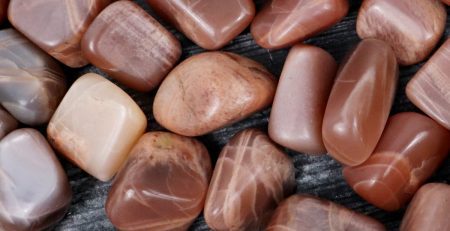 A pile of red and brown stones on a wooden surface.