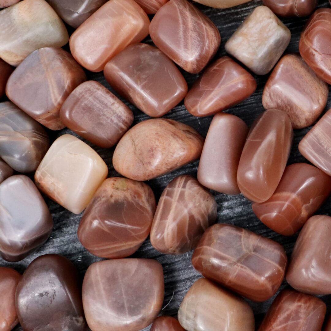 A pile of red and brown stones on a wooden surface.