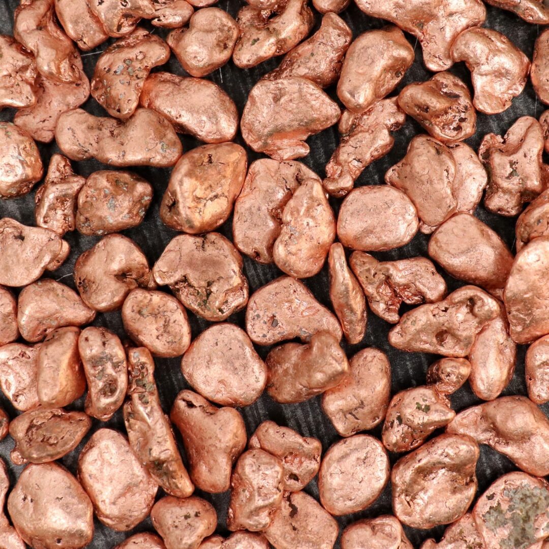 Copper pebbles on a black background.