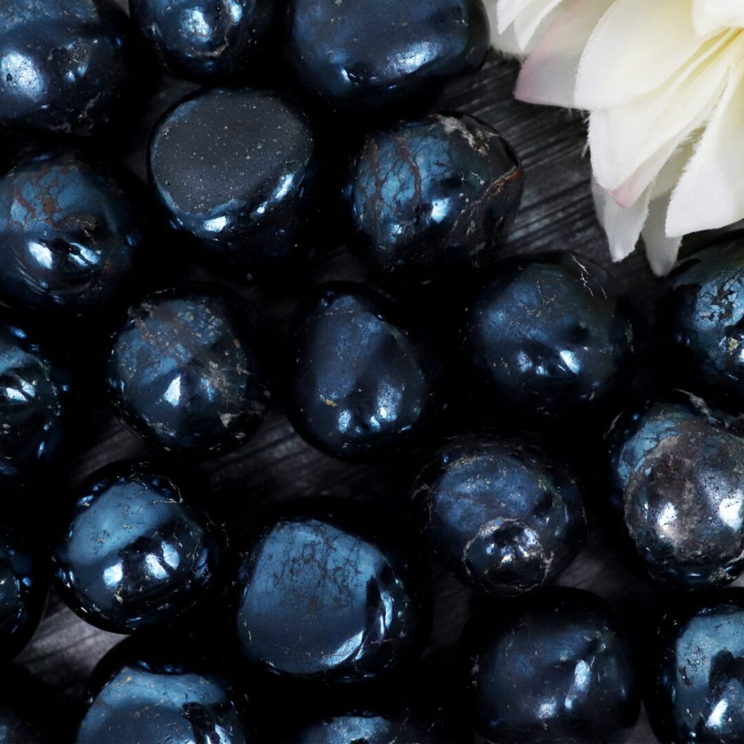 A bunch of black pearls on a wooden table.