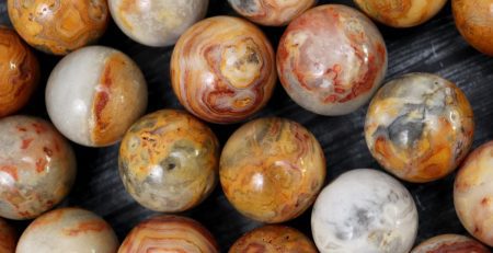 A bunch of brown and yellow marble beads on a table.