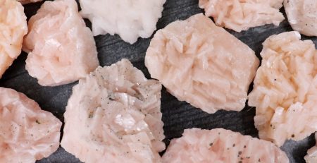 A pile of pink crystals on a black background.