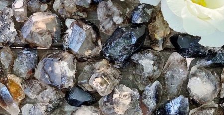 A bunch of crystals and flowers on a wooden surface.